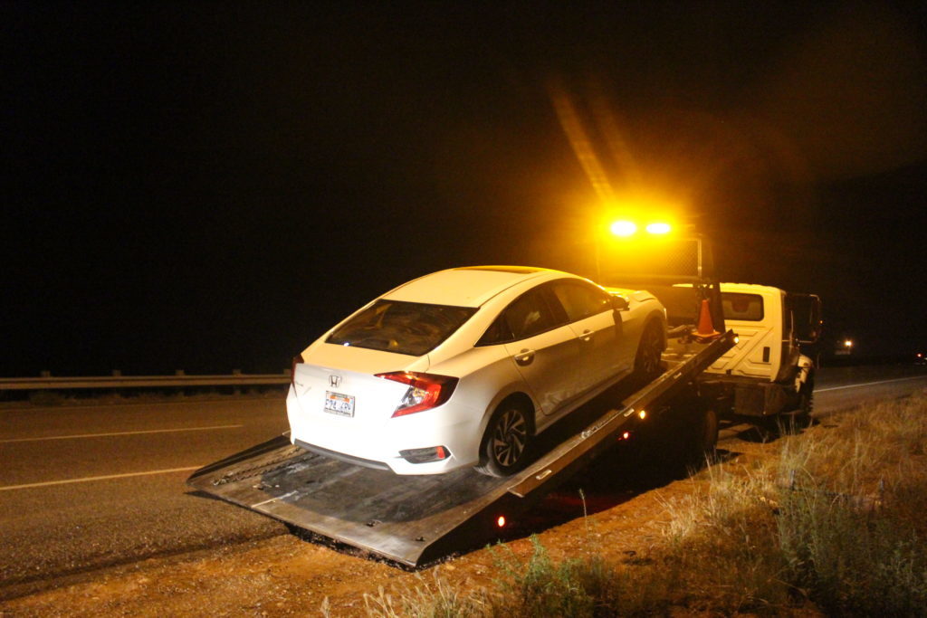 Un Honda de color blanco es remolcado después de que un colchón en la carretera causó una colisión en la carretera interestatal 15, el Condado de Washington, Utah, 10 de Nov., 2016 | Foto por Joseph Witham, Noticias St. George