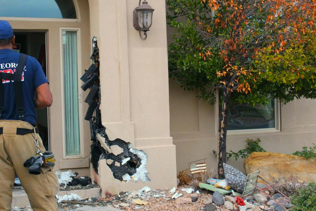 Los equipos de bomberos rompieron la columna y la pared adyacente donde un incendio comenzó en una residencia en 2830 Sur Miércoles, St. George, Utah, 30 de Nov., 2016 | Foto de Cody Blowers, Noticias St. George
